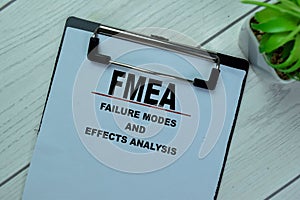 Concept of FMEA - Failure Modes and Effects Analysis write on paperwork isolated on Wooden Table