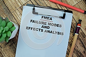 Concept of FMEA - Failure Modes and Effects Analysis write on paperwork isolated on Wooden Table photo