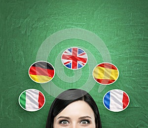 A concept of foreign language studying process. A foreseen of the brunette girl surrounded by icons of european flags.