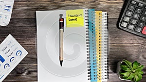 Concept of Fraudlent Loans write on sticky notes isolated on Wooden Table