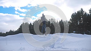 Concept freedom. man winter hands to the side stands in the snow next to the forest slow motion video. hike tourist in