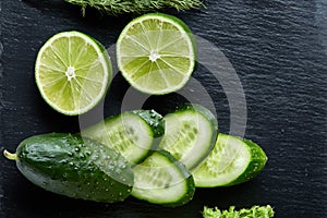 Concept of fresh green lettuce, cucumber, dill, lime on a light background, selective focus, top view, copy space.