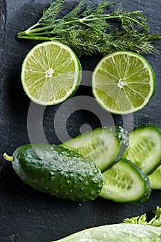 Concept of fresh green lettuce, cucumber, dill, lime on a light background, selective focus, top view, copy space.