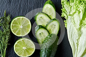 Concept of fresh green lettuce, cucumber, dill, lime on a light background, selective focus, top view, copy space.