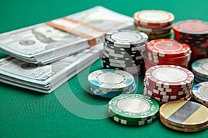 Concept of gambling in casino, sports poker. Gaming colored chips with cash cash dollars on green gaming table.