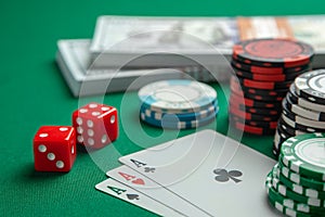 Concept of gambling in casino, sports poker. Playing cards with dice and colored chips with cash money dollars on green table.