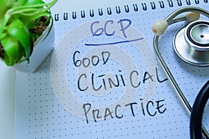 Concept of GCP - Good Clinical Practice write on book with stethoscope isolated on white background