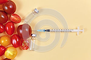 Geneticky upravené jedlo paradajky striekačka a prázdny zdravotné fľaštičky 