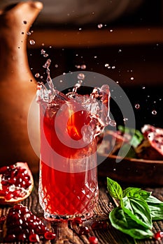 The concept of Georgian and Armenian cuisine. Cool drink with ice of basil and pomegranate juice in a glass goblet
