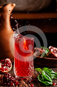 The concept of Georgian and Armenian cuisine. Cool drink with ice of basil and pomegranate juice in a glass goblet