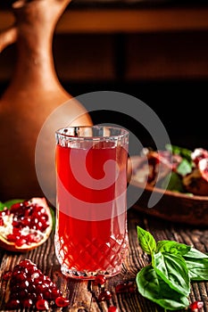 The concept of Georgian and Armenian cuisine. Cool drink with ice of basil and pomegranate juice in a glass goblet