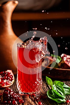 The concept of Georgian and Armenian cuisine. Cool drink with ice of basil and pomegranate juice in a glass goblet