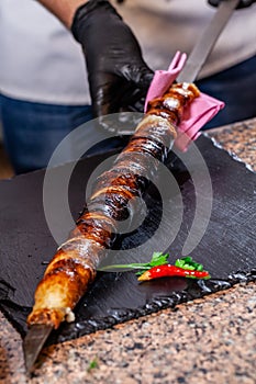 The concept of Georgian cuisine. Recipe for cooking meat lyulya kebab in the dough on the grill. Chef puts meat on a skewer