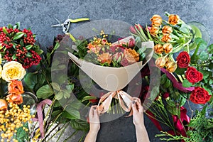 The concept of gifts and bouquets for March 8 and Mother`s Day. Florist creates a bouquet in a flower shop. Top view of