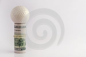 Concept of golfer competitions for money, financial risk, corruption, or sports betting. Golf ball on top of a roll of US hundred