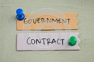 Concept of Government Contract write on sticky notes isolated on Wooden Table