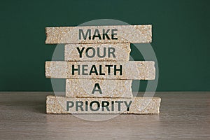 Concept green words Make your health a priority on brick blocks on a beautiful green background. Psychological mental health