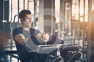 Concept of Gym, Fitness, Sport, Healthy, Lifestyle. Fit young man sit ups on machine in sportswear.