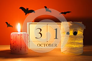 The concept for Halloween. Mummy from a can, gauze and candles, a wooden calendar showing October 31.