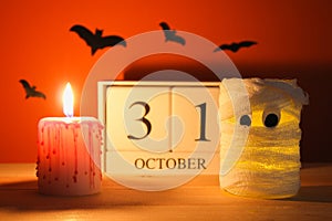 The concept for Halloween. Mummy from a can, gauze and candles, a wooden calendar showing October 31. photo