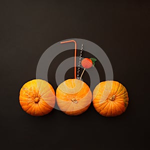 Concept of Halloween pumpkin orange cocktails on mystery black background. Festive drink, minimal trend.
