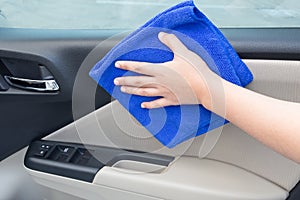 Concept of Hand cleaning interior car door panel with microfiber