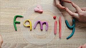 Concept of happy family. Hands spread in color letters word Family of plasticine