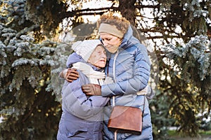 Concept of happy family, old age, emotions, senior care in retirement age. Active senior grandmother and adult daughter hugging