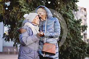 Concept of happy family, old age, emotions, senior care in retirement age. Active senior grandmother and adult daughter hugging