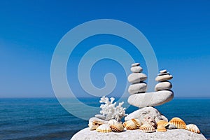 Concept of harmony and balance. Rock Zen of seashells on a background of summer sea.