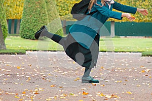 The concept of haste and tardiness. A woman is fooling around and having fun in the Park, against the background of yellow trees.