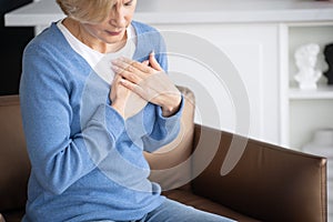 Mature woman feeling heart pain and chest tightness photo