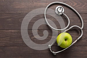 Concept for healthcare, Stethoscope and green apple on wooden ba