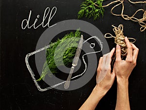 Concept of healthy eating, process of cooking, a healthy lifestyle. Hands of a woman, fresh dill on a hand-drawn cutting board, kn