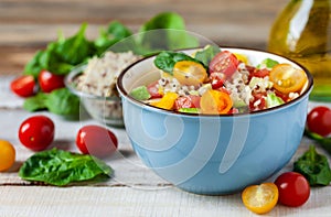 Concept of healthy food, clean eating, low calories delicious meal. Salad with quinoa and fresh vegetables with olive oil in blue