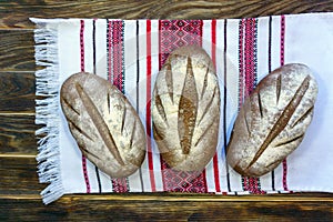 The concept of healthy food and natural products. Rustic still life - three loaves of wheat-rye bread on a towel close-up.