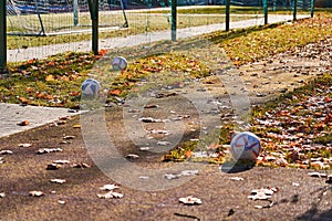 The concept of a healthy lifestyle. Three balls are lying on the grass near the stadium