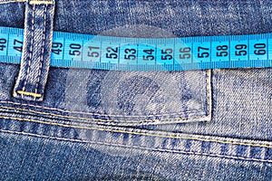 Concept of healthy lifestyle, weight loss. Jeans with measuring tape