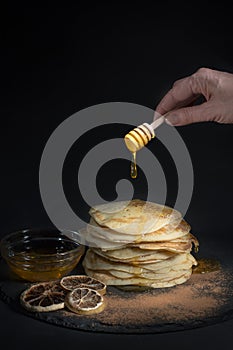 Concept healthy pancakes with honey on black background