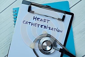 Concept of Heart Catheterization write on paperwork with stethoscope isolated on Wooden Table