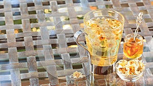 Concept of herbal tea. Camomile tea in a glass mug with honey. H