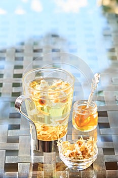 Concept of herbal tea. Camomile tea in a glass mug with honey. H
