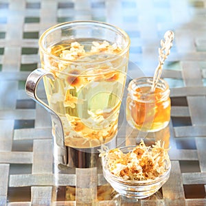 Concept of herbal tea. Camomile tea in a glass mug with honey. H