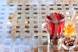 Concept of herbal tea. Hibiscus tea in a glass mug with honey. H