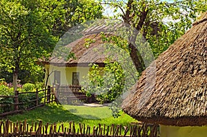 Concept of historical buildings in ancient Ukrainian village. Reconstruction of an ancient clay house with front yard