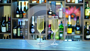 Concept of holiday, date. two glasses with champagne on the background of a rack with bottles