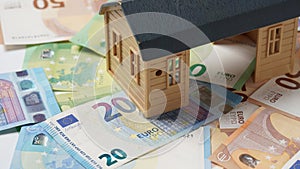 Concept of home ownership. New house and Euro money as a background. Invest in real estate