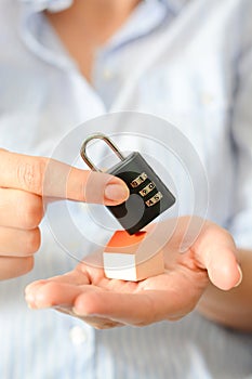 The concept of home security or insurance with cipher lock held on the roof of a miniature house photo