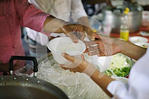 The concept of hope : Hand-feeding to the needy in society : Concept of Feeding : Volunteers give food to the poor : donating food