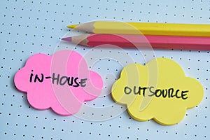 Concept of In-House or Outsource write on sticky notes isolated on Wooden Table photo